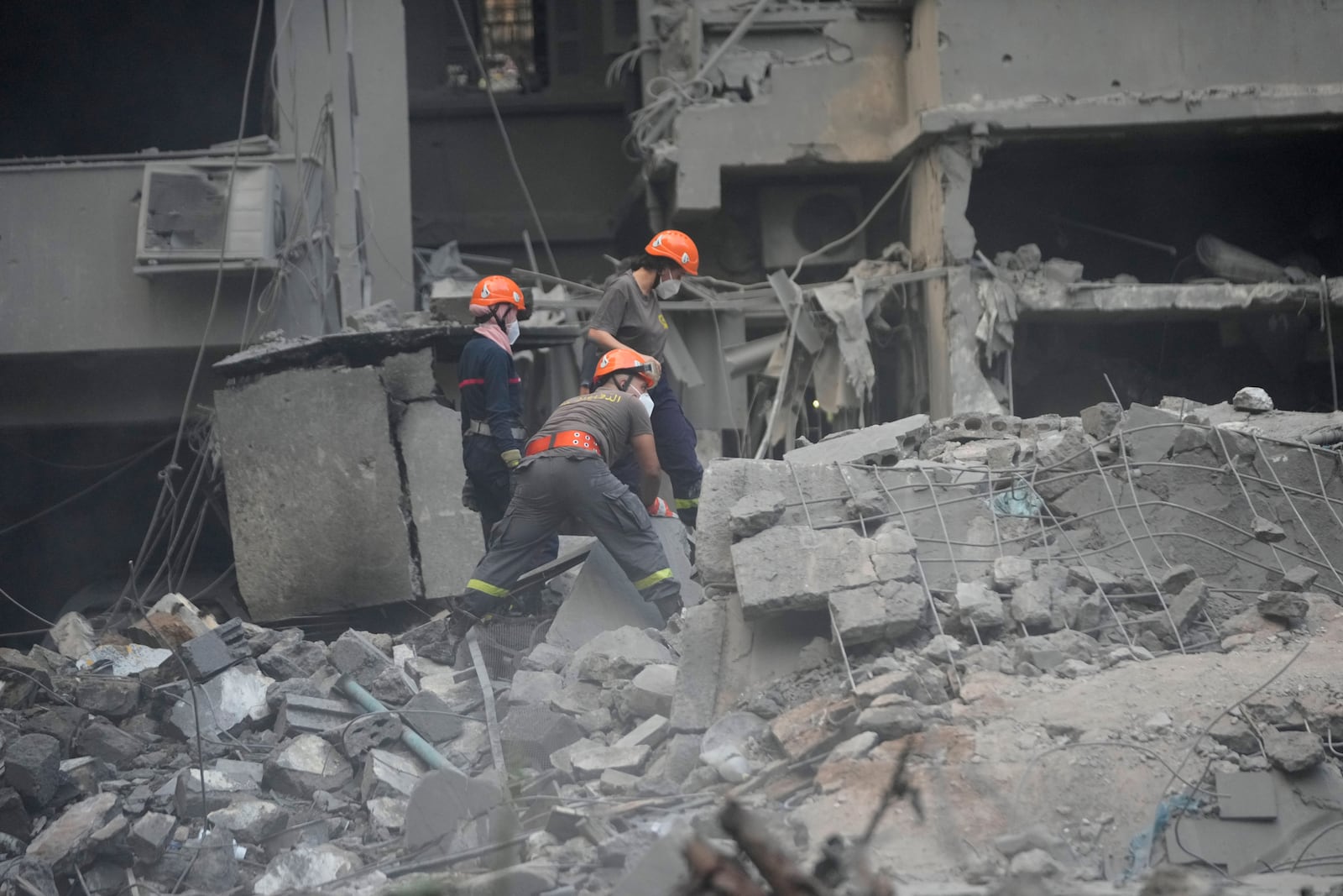 Rescue workers clear the rubble of destroyed buildings as they search for victims at the site of Thursday's Israeli airstrike, in Beirut, Lebanon, Friday, Oct. 11, 2024. (AP Photo/Hussein Malla)