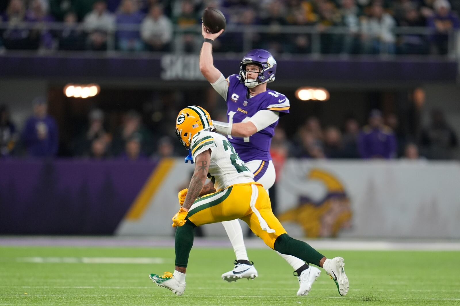 Minnesota Vikings' Sam Darnold throws while being pressured by Green Bay Packers' Keisean Nixon during the first half of an NFL football game Sunday, Dec. 29, 2024, in Minneapolis. (AP Photo/Abbie Parr)