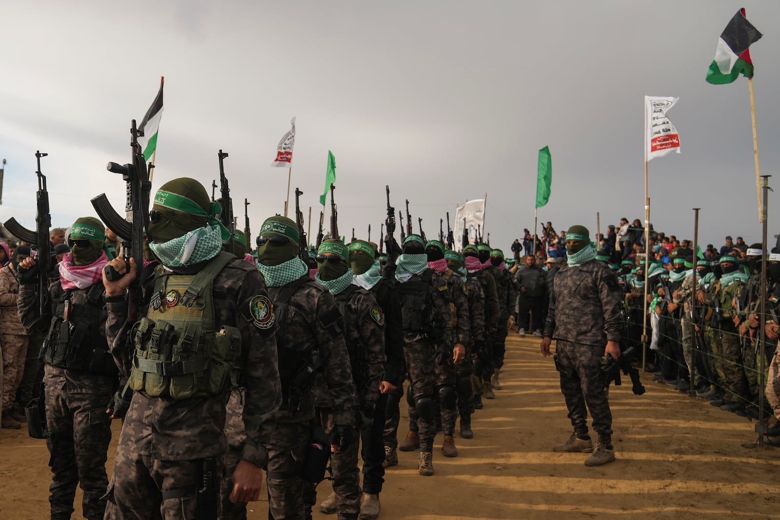 Hamas fighters deploy ahead of handing over the bodies of four Israeli hostages, including a mother and her two children, who had long been feared dead, to the Red Cross in Khan Younis, southern Gaza Strip, Thursday, Feb. 20, 2025. (AP Photo/Abdel Kareem Hana)