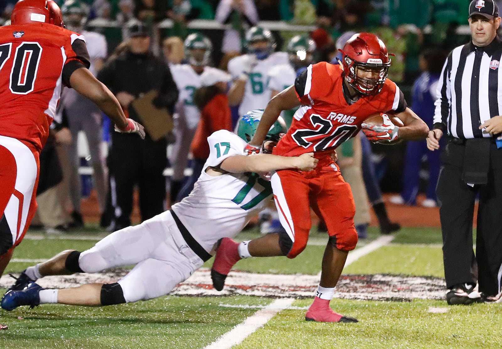 Trotwood’s Devontay Latimer tries to break a tackle by C.J.’s Anthony Burneka as he carries the ball during a Division III regional final Nov. 17, 2017. Bill Lackey/STAFF