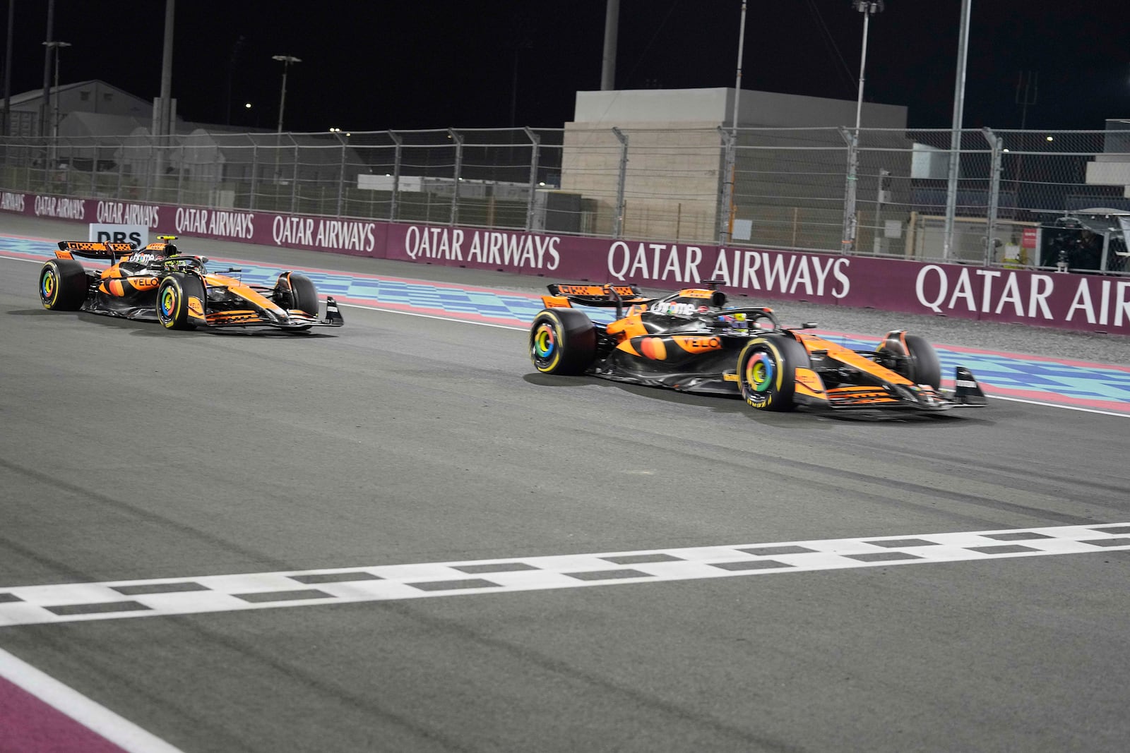 McLaren driver Oscar Piastri of Australia crosses the finish line followed by his teammate McLaren driver Lando Norris of Britain during sprint race at the Formula One Qatar Grand Prix, at the Lusail International Circuit in Lusail, Qatar, Saturday, Nov. 30, 2024. (AP Photo/Pool/ Altaf Qadri)