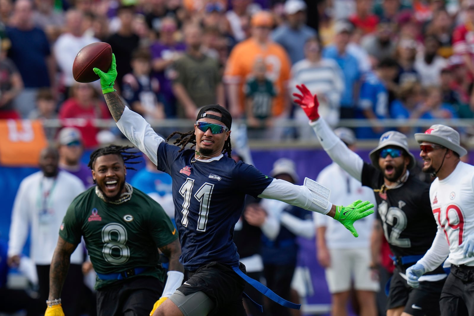 NFC wide receiver Jaxon Smith-Njigba (11), of the Seattle Seahawks, celebrates on his way to scoring a touchdown during the flag football event at the NFL Pro Bowl, Sunday, Feb. 2, 2025, in Orlando. (AP Photo/Chris O'Meara)