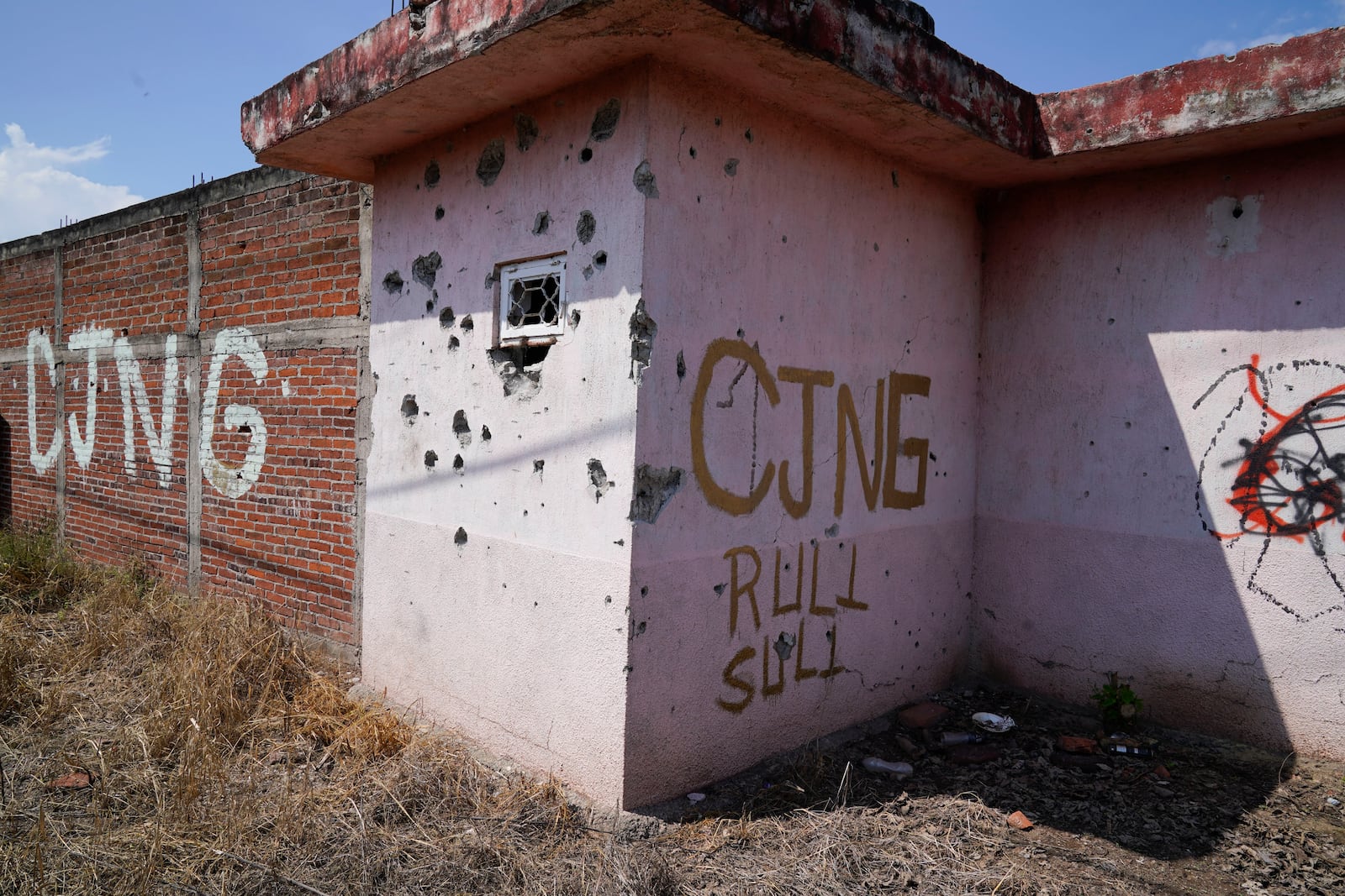 FILE - The letters "CJNG" which stands for "Jalisco New Generation Cartel" cover an abandoned home in El Limoncito, Michoacan state, Mexico, Oct. 30, 2021. (AP Photo/Eduardo Verdugo, File)