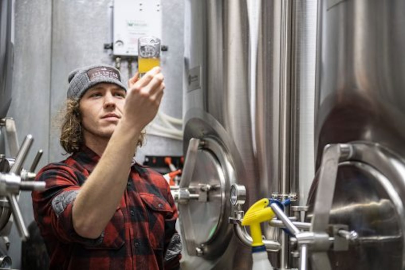 Music education alumnus Doug Lane checks out one of Devil Wind Brewery’s beers. Contributed