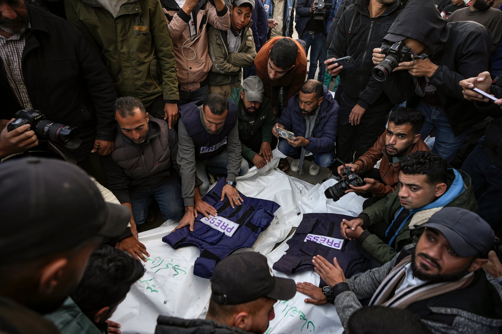 Palestinians, mostly journalists, gather around the bodies of five Palestinian journalists who were killed by an Israeli airstrike in Gaza City, at the Al-Aqsa Hospital in Deir al-Balah, Thursday, Dec. 26, 2024. (AP Photo/Abdel Kareem Hana)