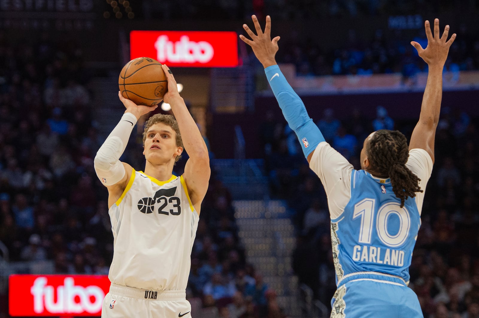 Utah Jazz Lauri Markkanen (23) shoots as Cleveland Cavaliers' Darius Garland (10) defends during the first half of an NBA basketball game in Cleveland, Monday, Dec. 23, 2024. (AP Photo/Phil Long)