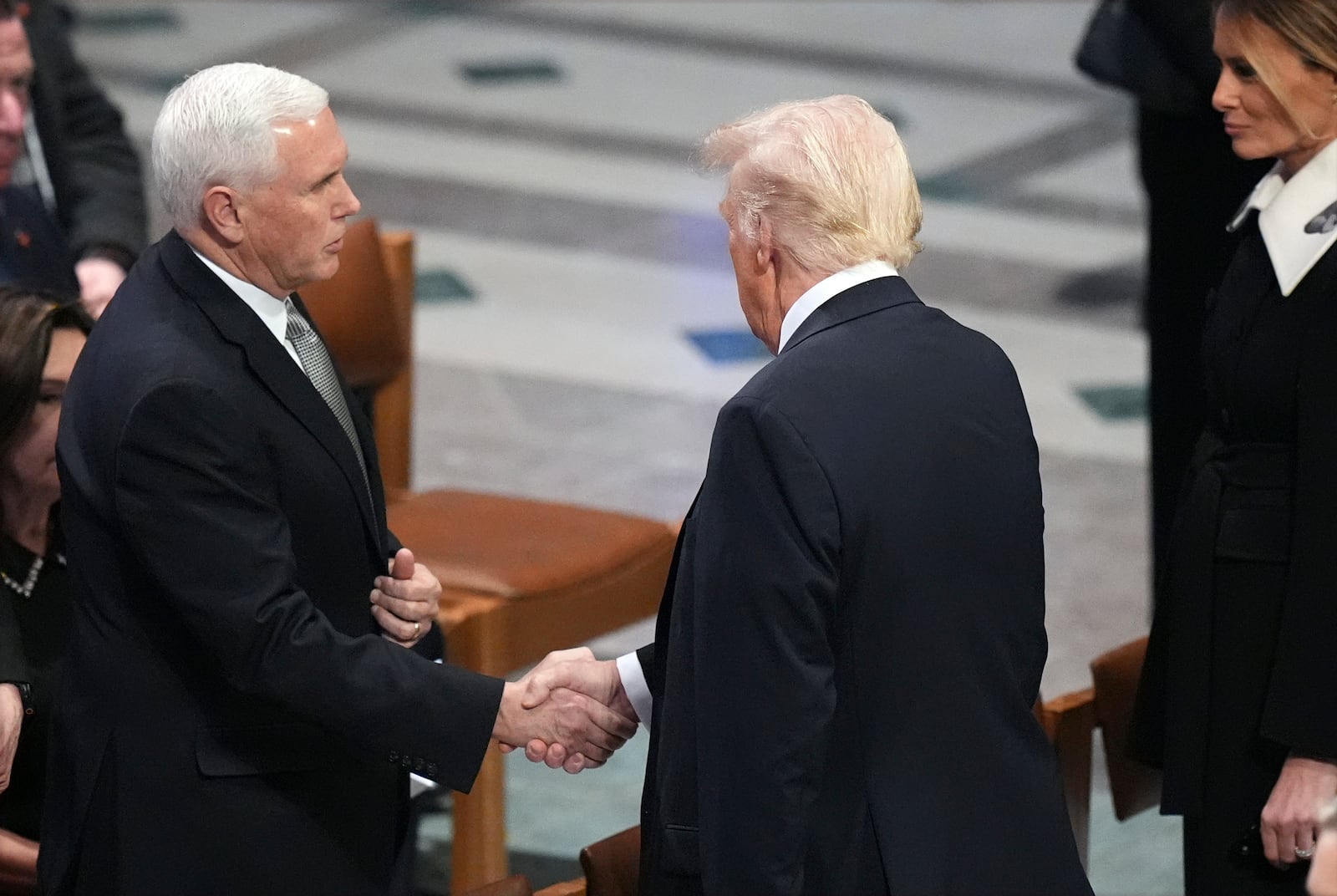 President-elect Donald Trump shakes hands with former Vice President Mike Pence as Melania Trump watches before the state funeral for former President Jimmy Carter at Washington National Cathedral in Washington, Thursday, Jan. 9, 2025. (AP Photo/Jacquelyn Martin)