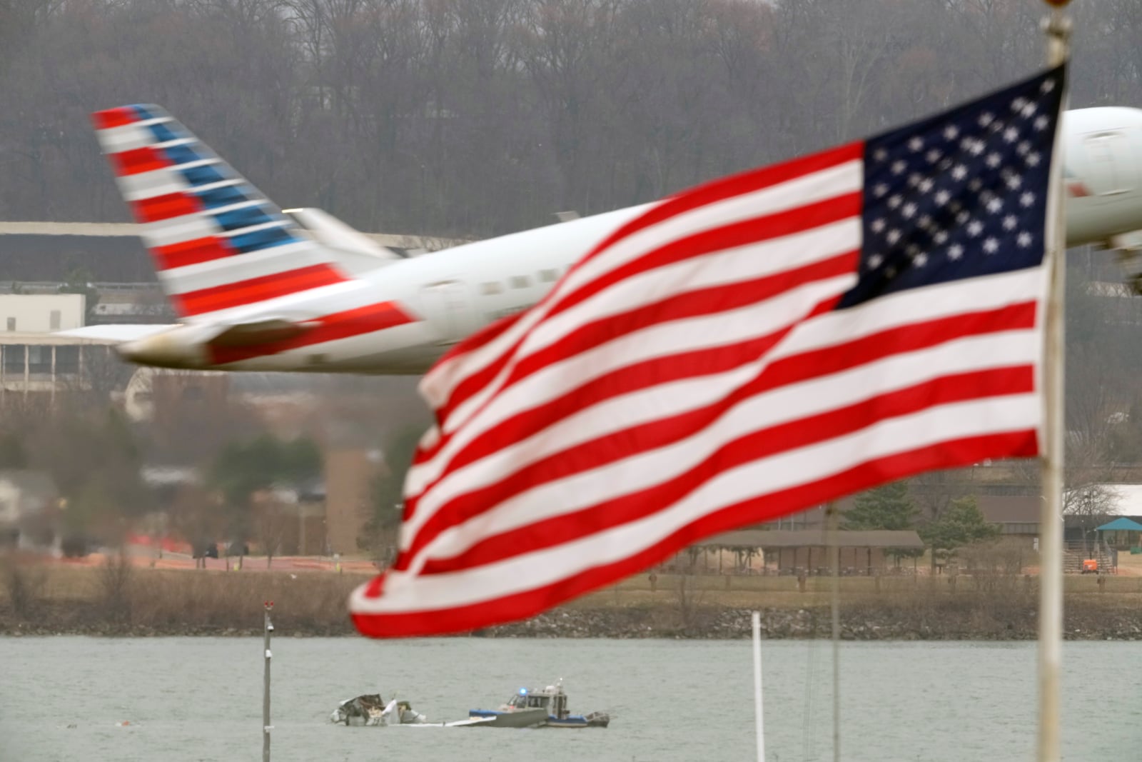 Search efforts are seen around a wreckage site of a deadly midair collision between an American Airlines jet and an Army helicopter, in the Potomac River near Ronald Reagan Washington National Airport, Friday, Jan. 31, 2025, in Arlington, Va., as an American Airlines jet lifts off from the airport. (AP Photo/Alex Brandon)