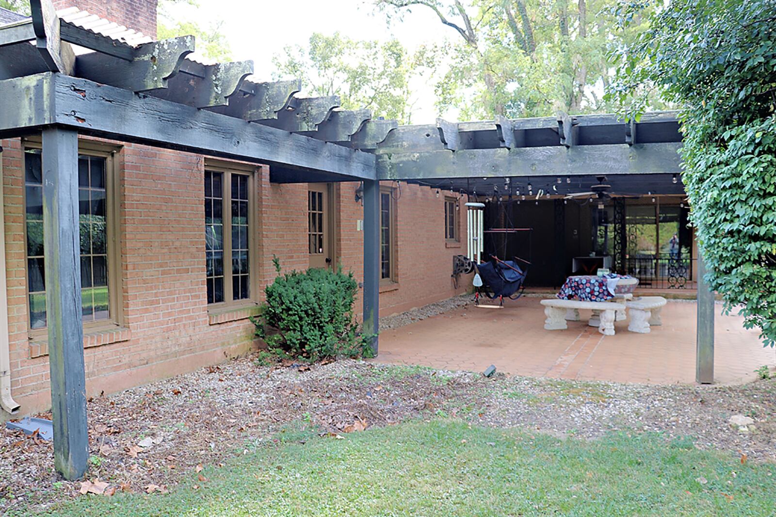 An oversized sliding patio door with wrought-iron accents opens out to a covered porch with wrought-iron supports and terra-cotta tile flooring. CONTRIBUTED PHOTO BY KATHY TYLER