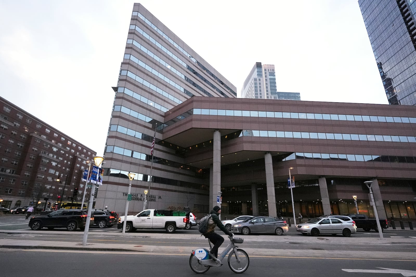 A cyclist rolls past the Thomas P. O'Neill Jr. Federal Building, Tuesday, March 4, 2025, in Boston. (AP Photo/Charles Krupa)