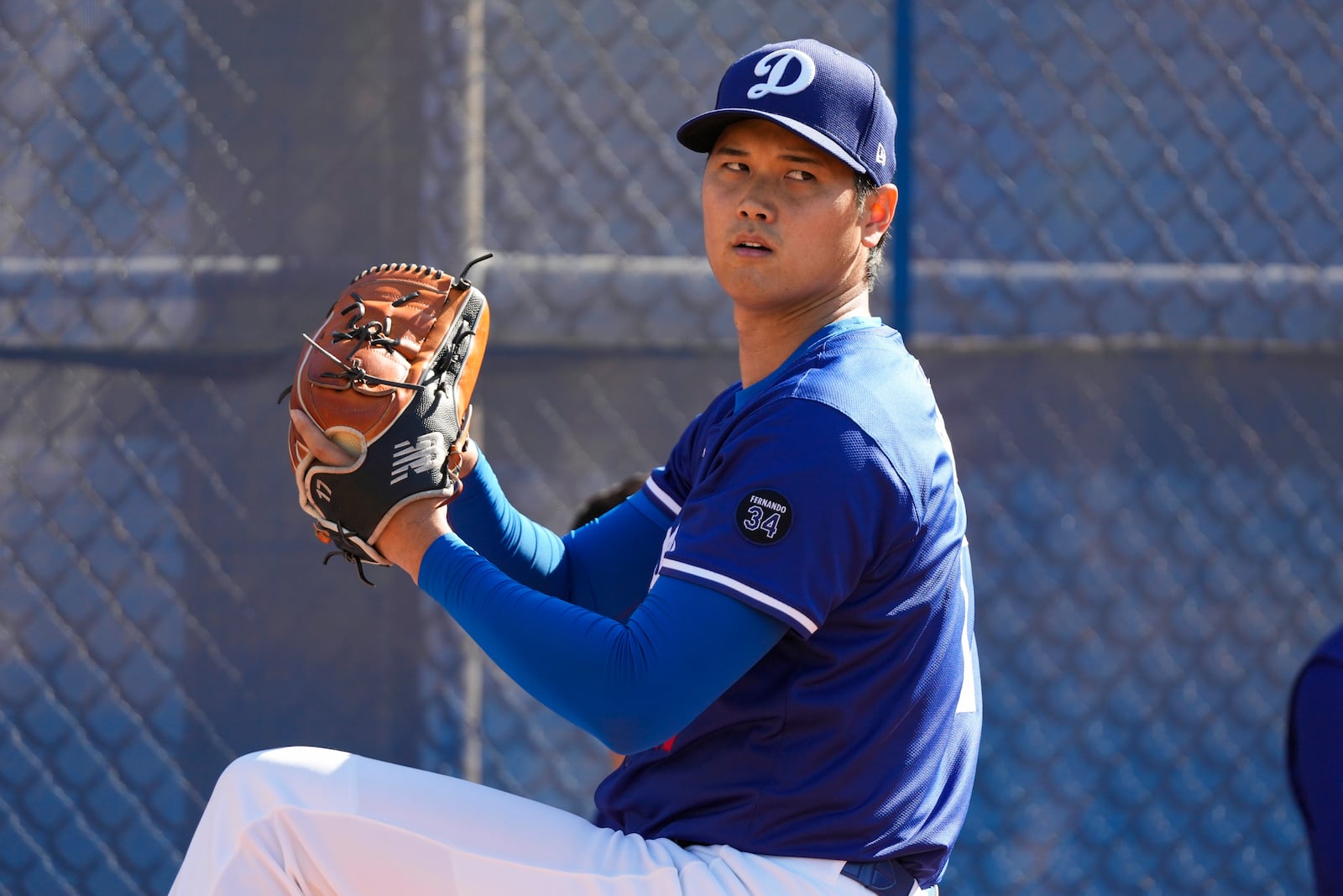 Los Angeles Dodgers two-way player Shohei Ohtani (17) throws in the bullpen during spring training baseball practice, Tuesday, Feb. 18, 2025, in Phoenix. (AP Photo/Ashley Landis)