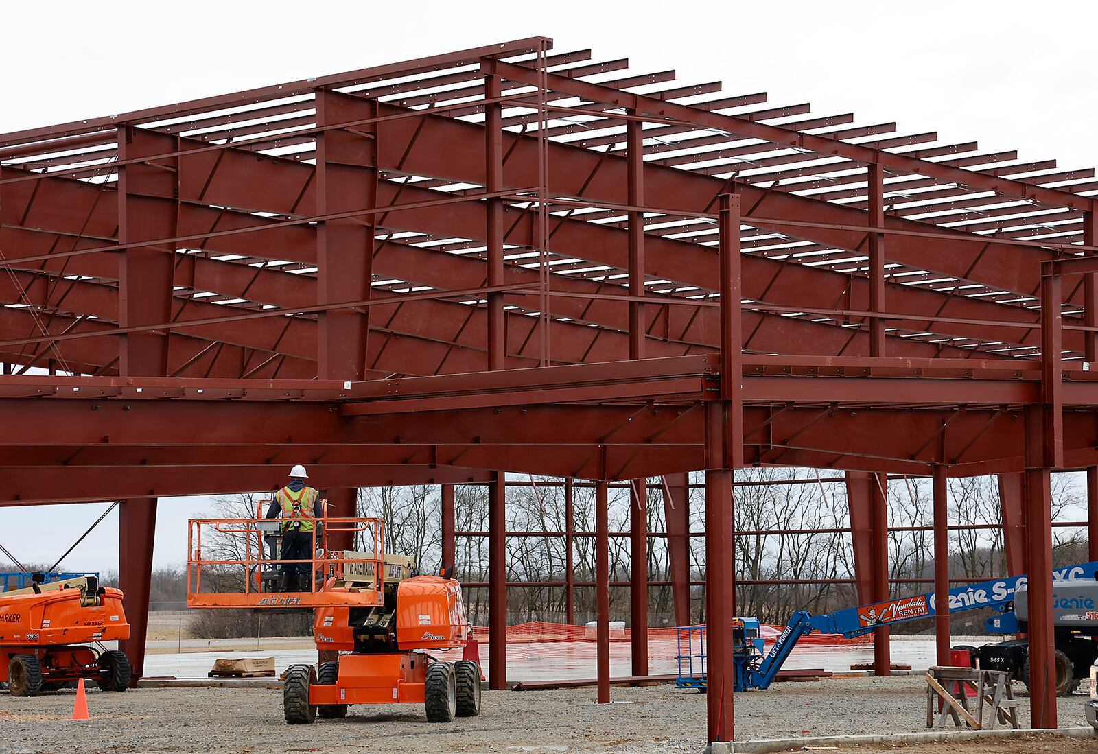 A worker maneuvers a lift into place as work continues on the National Advanced Air Mobility Center of Excellence at the Springfield Beckley Airport on Feb. 16, 2023. BILL LACKEY/STAFF