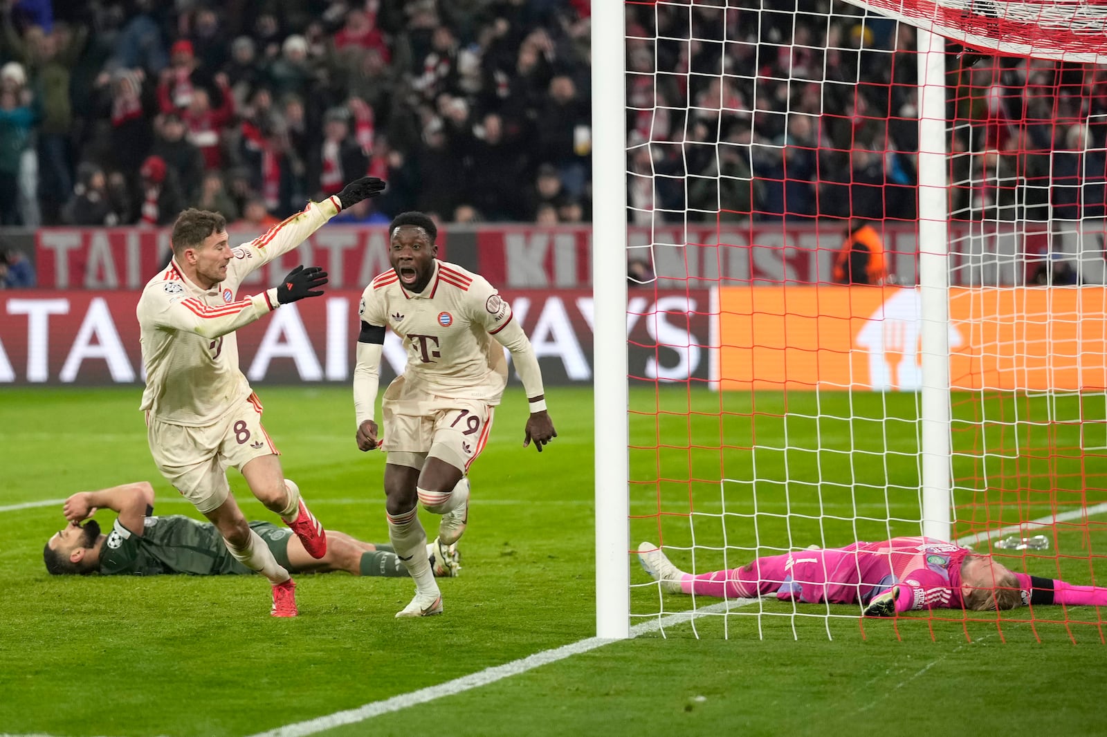 Bayern's Alphonso Davies, centre, celebrates after scoring his side's opening goal during the Champions League playoff second leg soccer match between FC Bayern Munich and Celtic Glasgow at the Allianz Arena in Munich, Germany, Tuesday, Feb. 18, 2025. (AP Photo/Matthias Schrader)