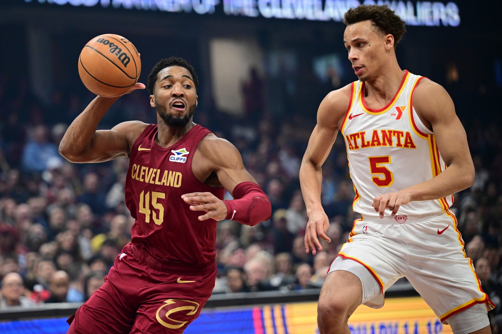 Cleveland Cavaliers guard Donovan Mitchell, left, goes to the basket against Atlanta Hawks guard Dyson Daniels, right, in the first half of an NBA basketball game, Thursday, Jan. 30, 2025, in Cleveland. (AP Photo/David Dermer)