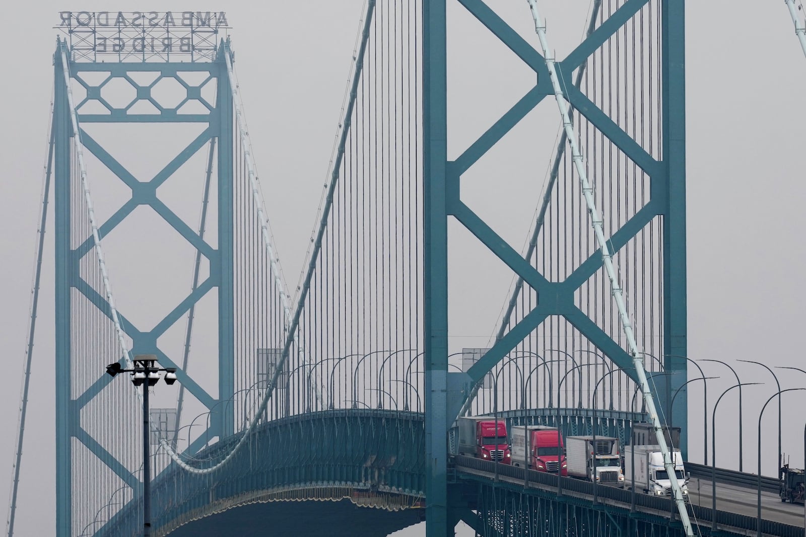 Trucks enter into the United States from Ontario, Canada across the Ambassador Bridge, Monday, Feb. 3, 2025, in Detroit. (AP Photo/Paul Sancya)