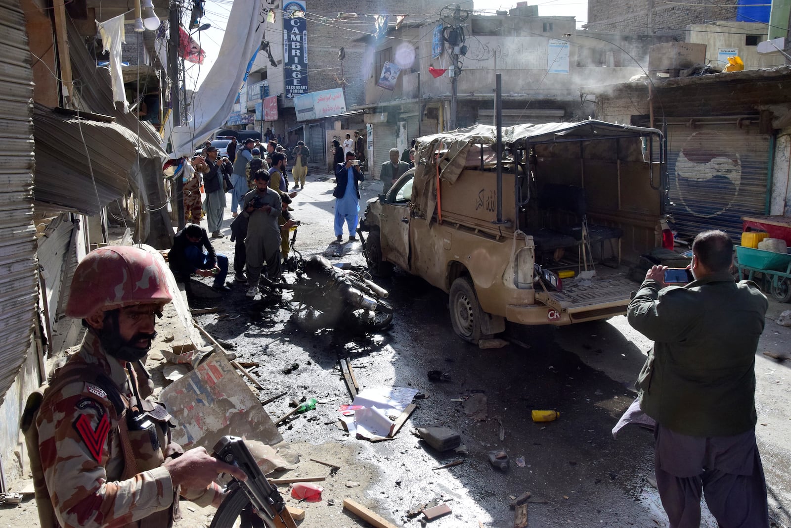 Security officials examine a damaged security forces' vehicle at the site of a bomb blast in Quetta, Pakistan, Friday, Feb. 28, 2025. (AP Photo/Arshad Butt)