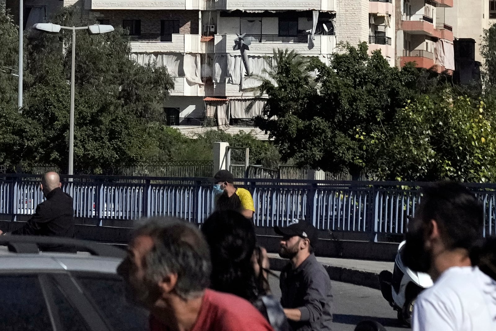 People duck down as a missile launched from an Israeli jet hits a building in Ghobeiri, Beirut, Lebanon, Tuesday, Oct. 22, 2024. (AP Photo/Bilal Hussein)