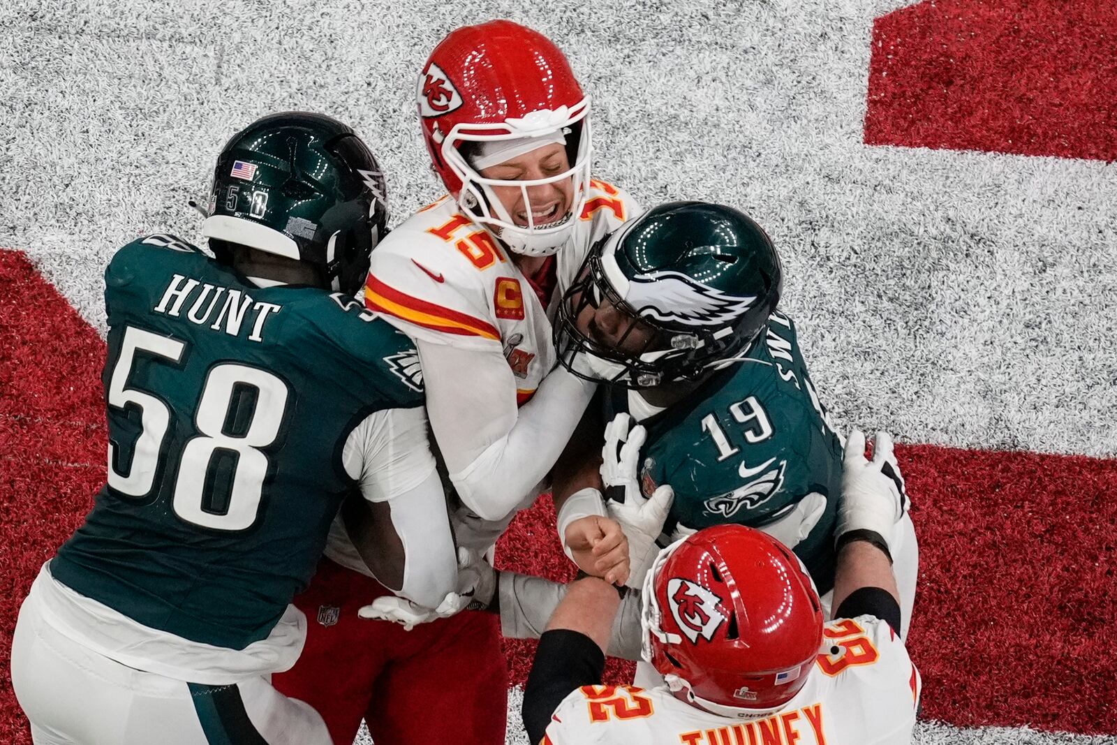 Kansas City Chiefs quarterback Patrick Mahomes (15) is hit by Philadelphia Eagles linebackers Jalyx Hunt (58) and Josh Sweat (19) during the second half of the NFL Super Bowl 59 football game, Sunday, Feb. 9, 2025, in New Orleans. (AP Photo/David J. Phillip)