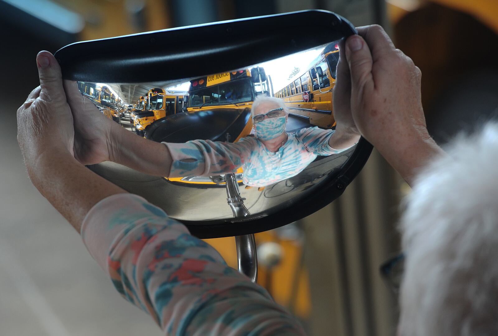 Carol Huff, a bus driver for the Kettering school districts for 37 years, checks the mirrors on her bus. Huff has a daily checklist to make sure the bus is safe. MARSHALL GORBY\STAFF