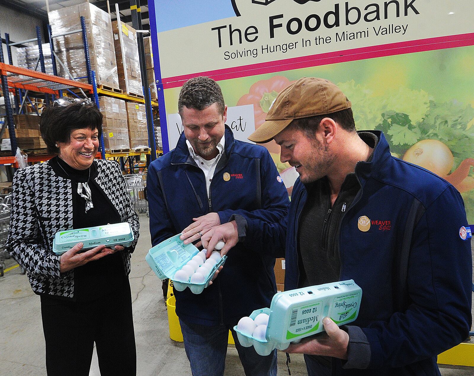 Michelle Riley, CEO of the Dayton Foodbank, left, Zach Kohli and Tim Weaver from Weaver Eggs look over three dozen of 54,000 eggs Weaver Eggs donated to The Foodbank Inc. on Tuesday, March 28, 2023, in Dayton.  MARSHALL GORBY\STAFF