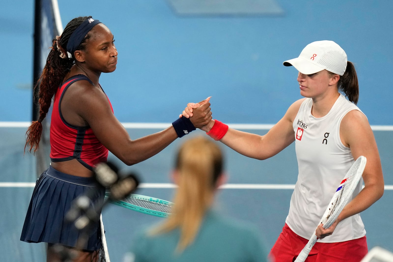 Coco Gauff of the U.S., left, shakes hands with Poland's Iga Swiatek after Gauff won their final match at the United Cup tennis tournament in Sydney, Australia, Sunday, Jan. 5, 2025. (AP Photo/Rick Rycroft)