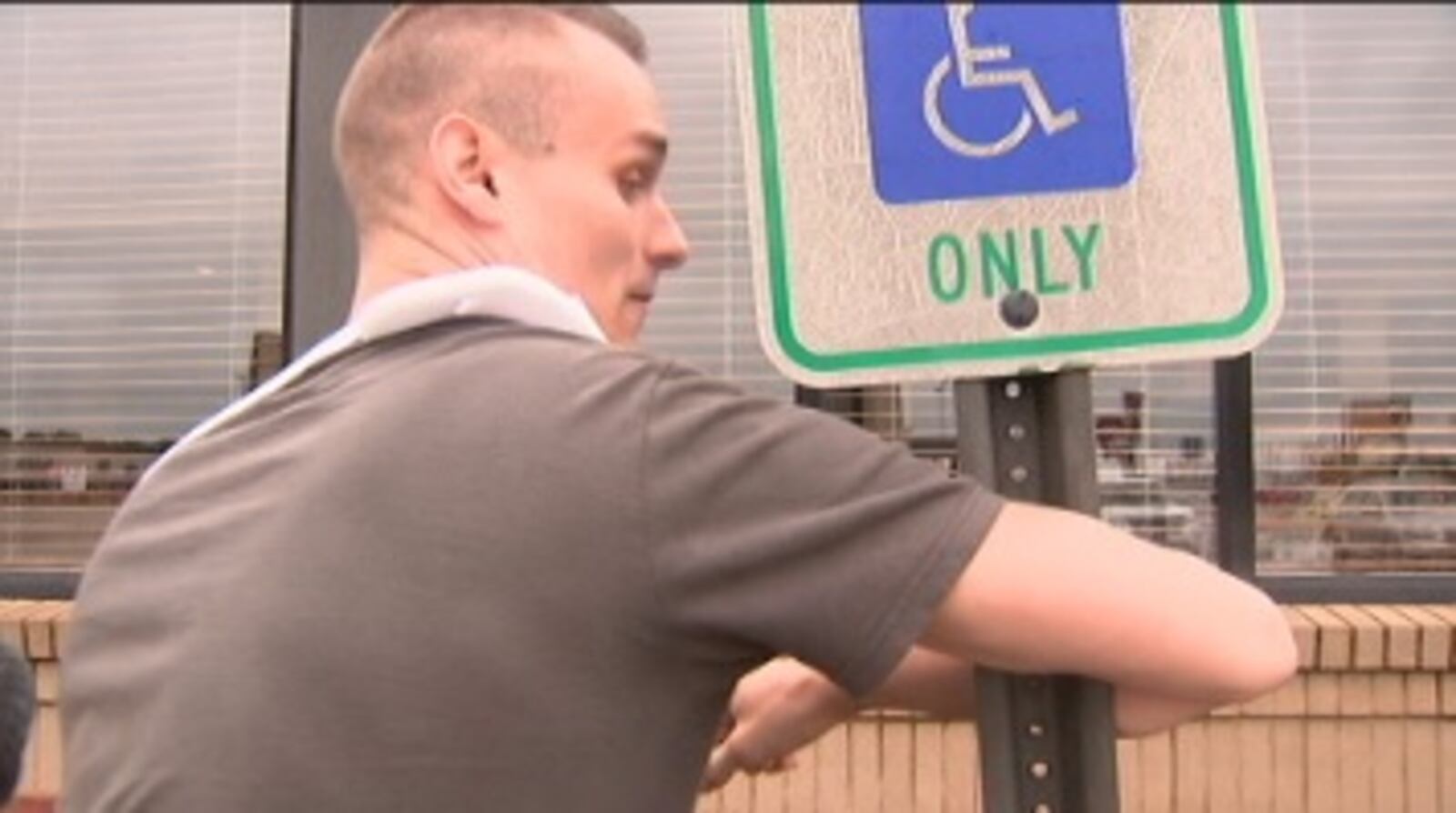 Jeremy Cantrell showing how he held onto the sign during the strong storm in Richmond.