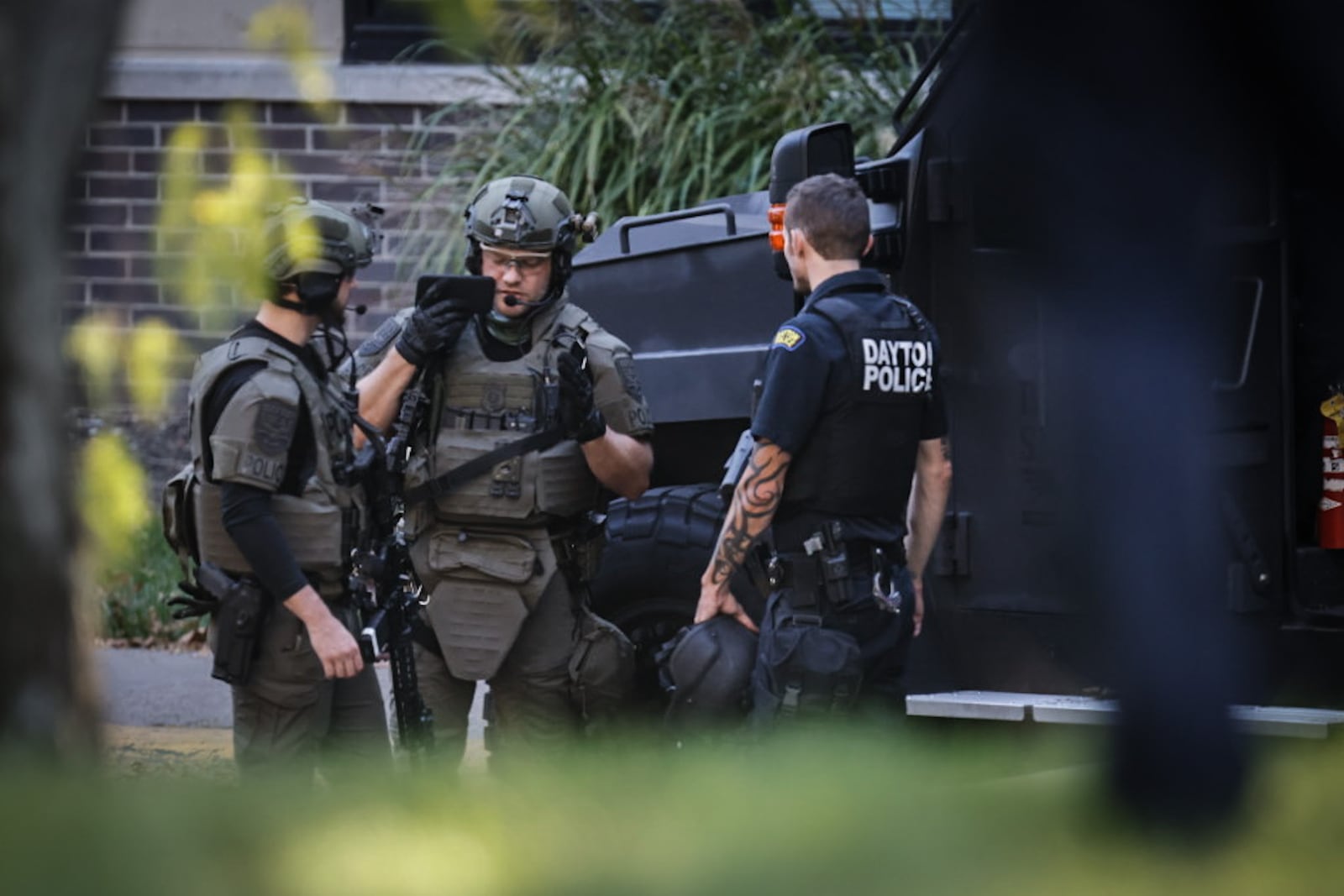 Officers surround a large apartment building on Wentworth Avenue Friday afternoon, Oct. 18, 2024, looking for a person who reportedly fled Dayton police. JIM NOELKER/STAFF