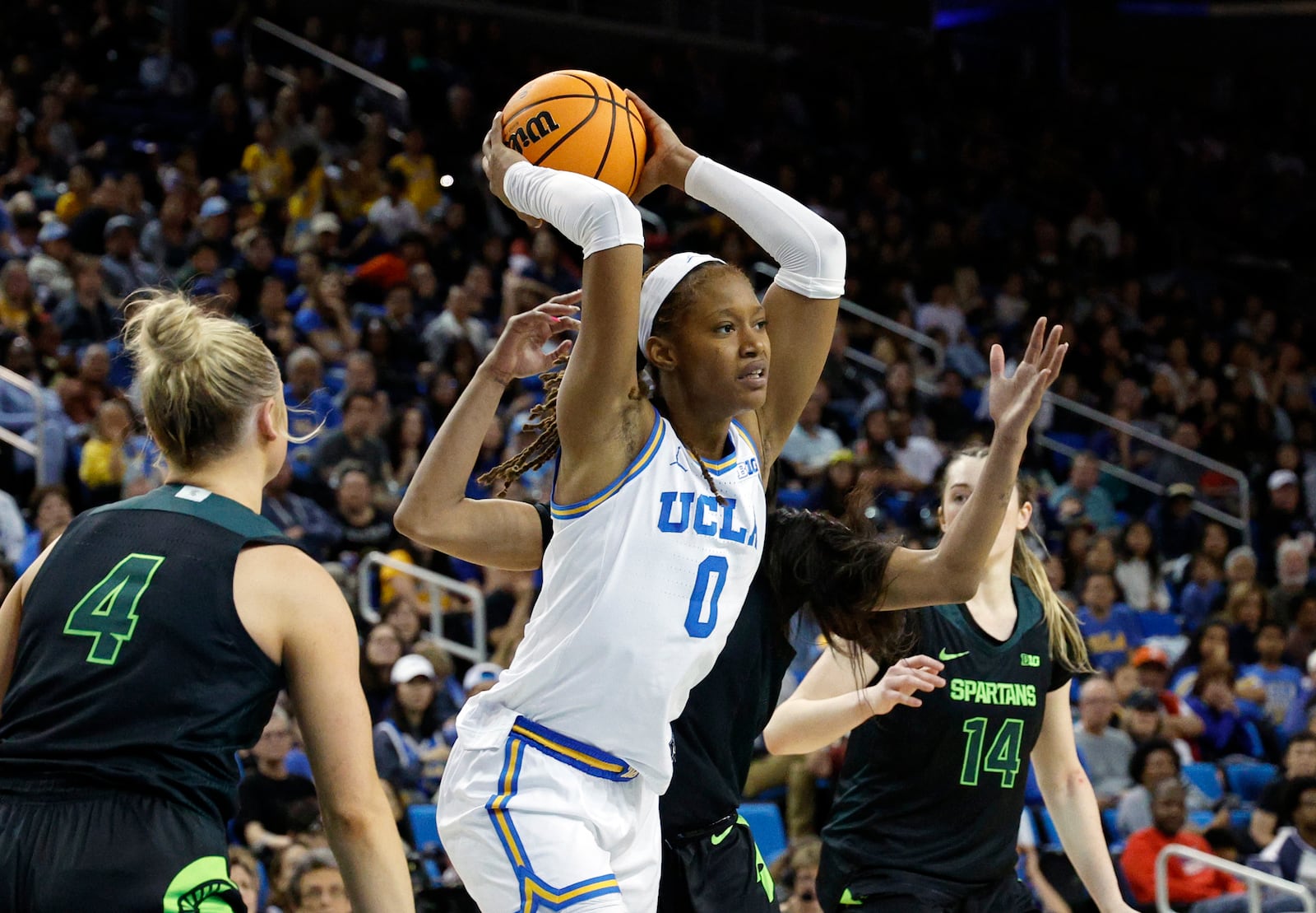 UCLA forward Janiah Barker throws a pass as she's defended by Michigan State guard Theryn Hallock during the second half of an NCAA college basketball game Sunday, Feb. 16, 2025, in Los Angeles. (AP Photo/Kevork Djansezian)