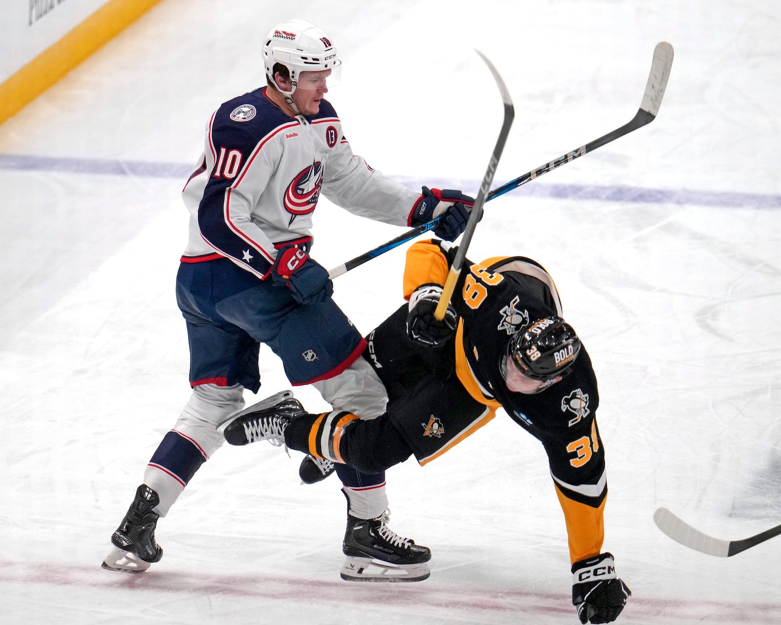 Columbus Blue Jackets' Dmitri Voronkov (10) checks Pittsburgh Penguins' Owen Pickering (38) off the puck during the first period of an NHL hockey game in Pittsburgh, Tuesday, Jan. 7, 2025. (AP Photo/Gene J. Puskar)