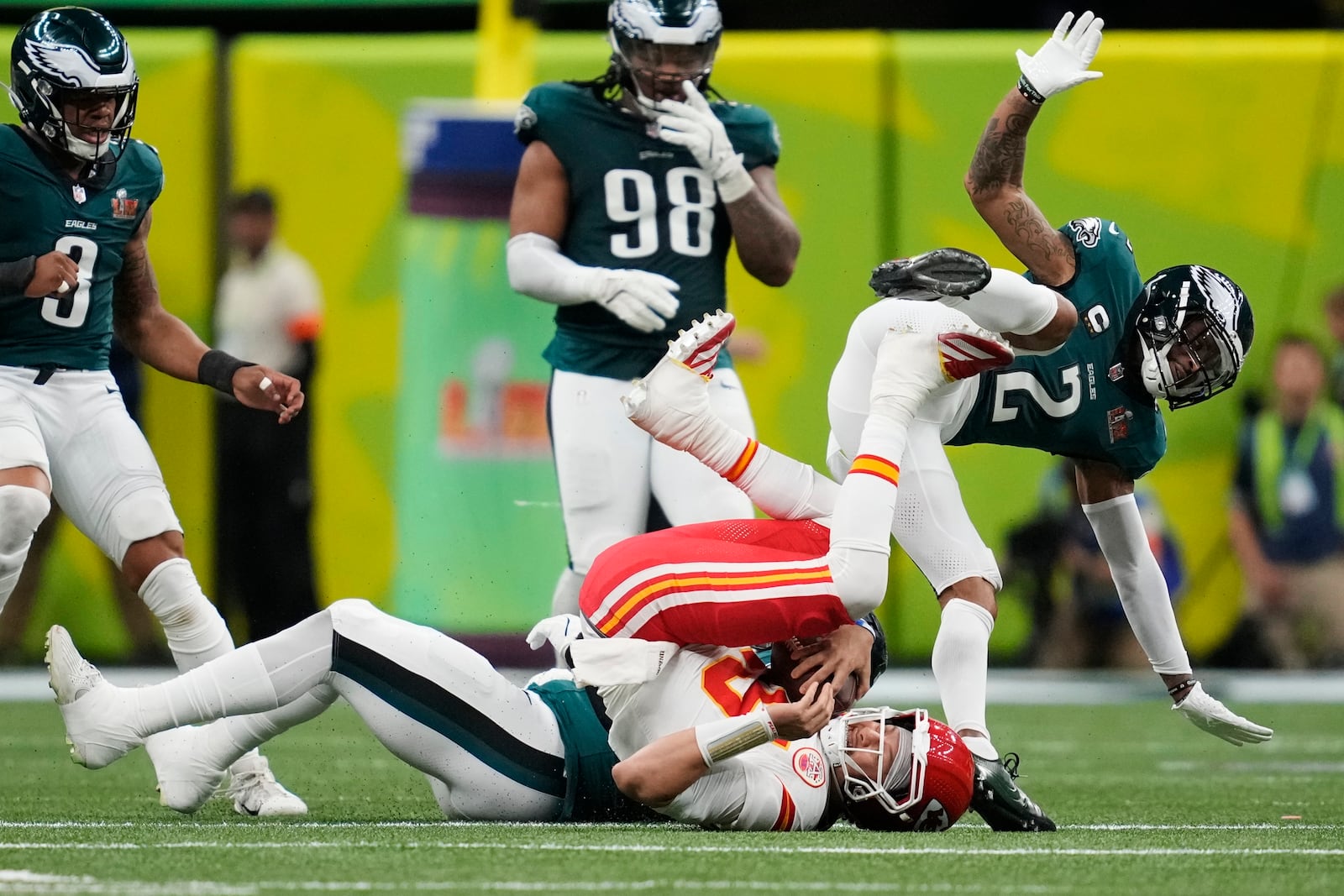 Kansas City Chiefs quarterback Patrick Mahomes (15) is tackled by Philadelphia Eagles defensive tackle Milton Williams as cornerback Darius Slay Jr. leaps over during the first half of the NFL Super Bowl 59 football game, Sunday, Feb. 9, 2025, in New Orleans. (AP Photo/Ashley Landis)