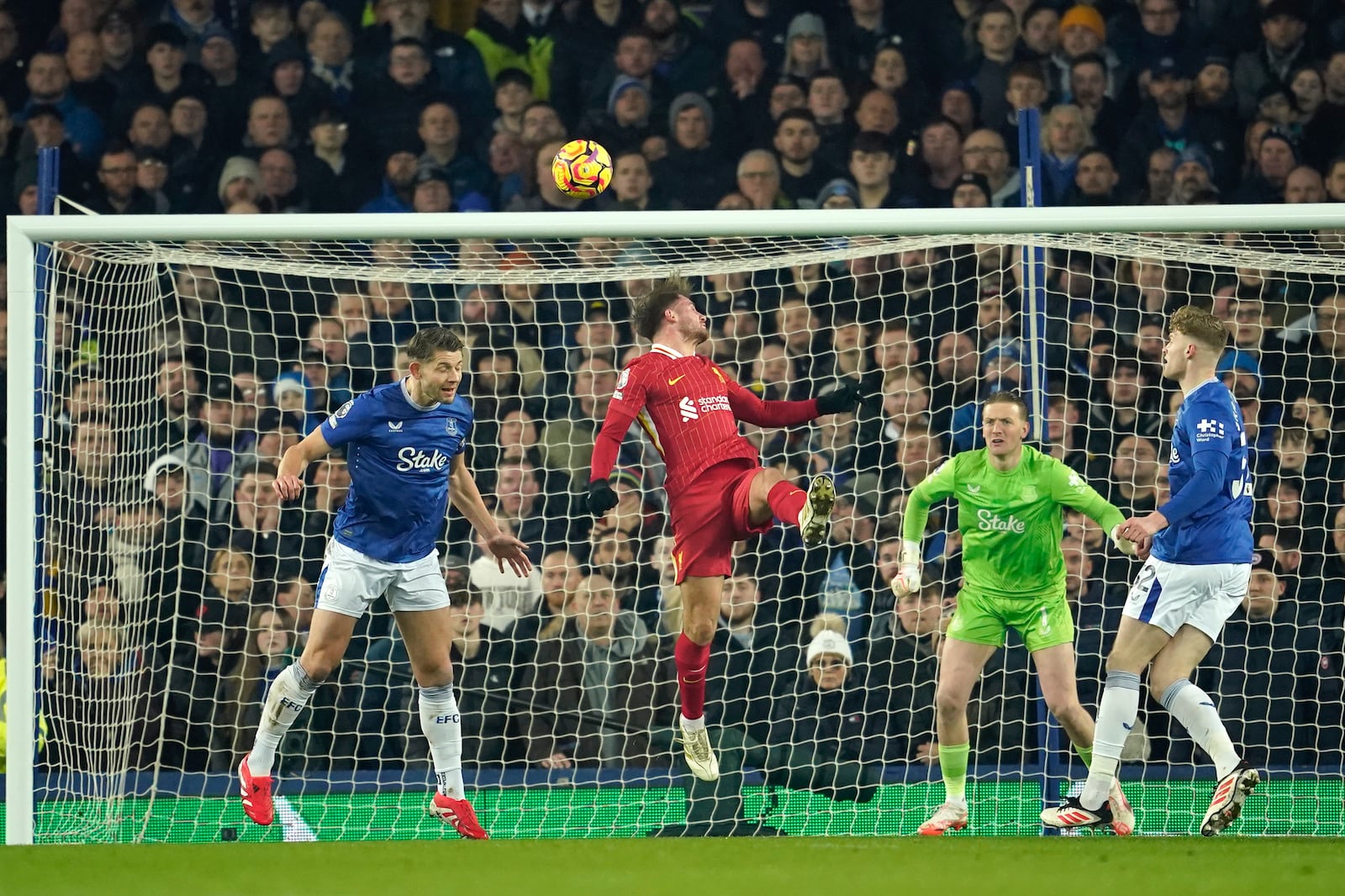 Liverpool's Alexis Mac Allister, centre, scores his side's opening goal during the English Premier League soccer match between Everton and Liverpool, Liverpool, England, Wednesday, Feb.12, 2025. (AP Photo/Dave Thompson)