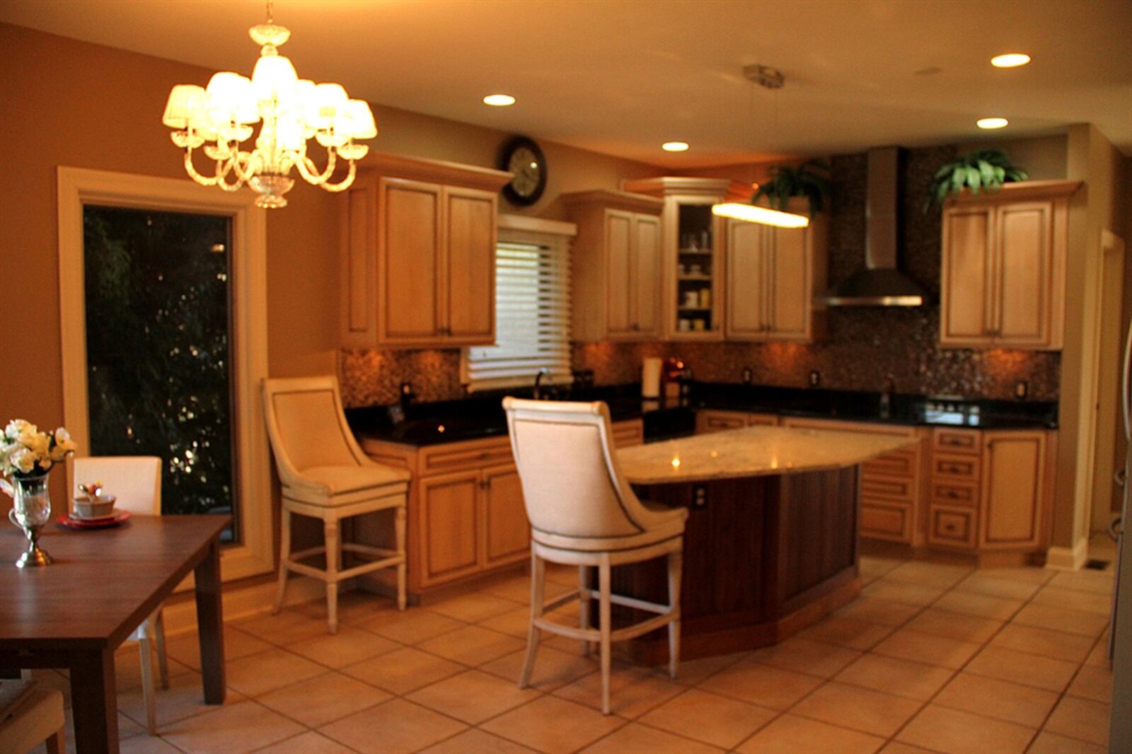 Tuscan-hued cabinets, granite counters, miniature-tile backsplashes and stainless-steel appliances surround the kitchen.