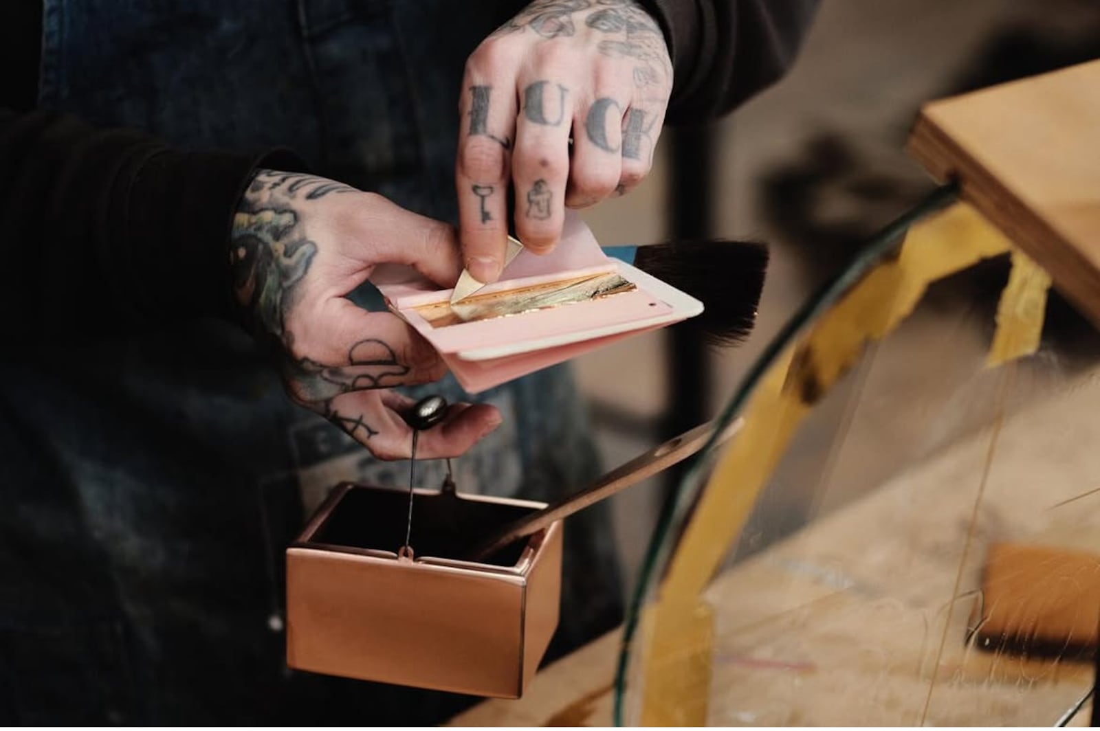 Josh Flohre of Ink & Hammer holds a Gilder's Pot, used to apply gold leaf to his hand painted signs.