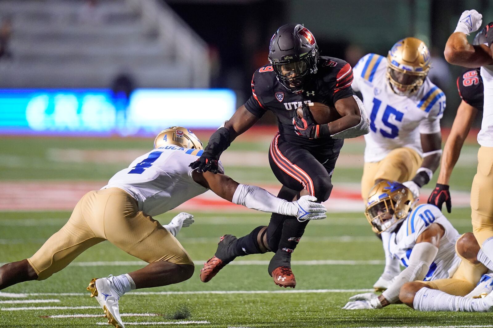 Utah running back Tavion Thomas (9) carries the ball for a touchdown as UCLA defensive back Stephan Blaylock (4) tries to defend in the second half during an NCAA college football game Saturday, Oct. 30, 2021, in Salt Lake City. (AP Photo/Rick Bowmer)