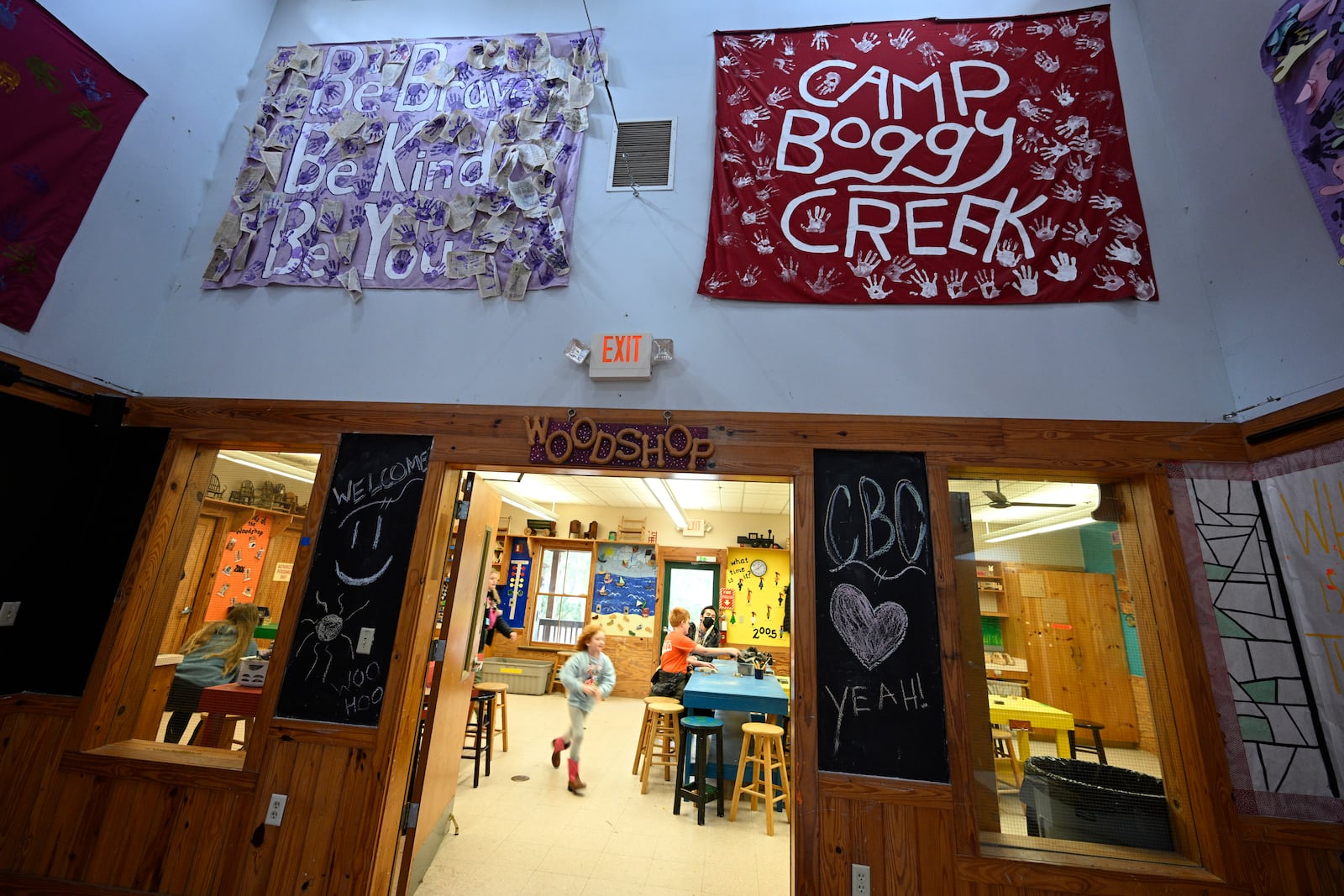 Volunteer counselors help children inside the workshop at Camp Boggy Creek, where children with serious illnesses and their families are provided with a free camp experience, Saturday, Jan. 11, 2025, in Eustis, Fla. (AP Photo/Phelan M. Ebenhack)