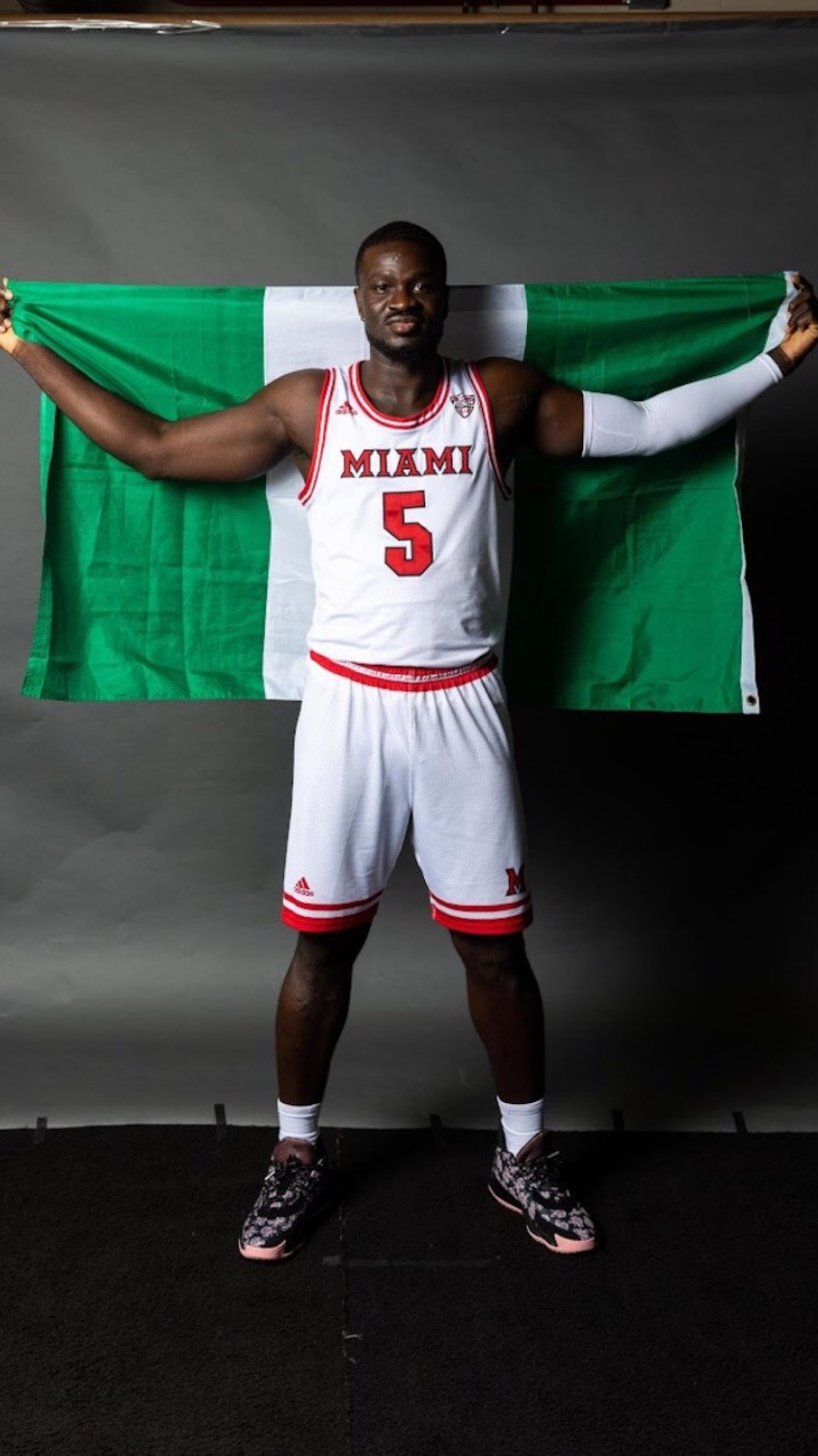 Miami's Precious Ayah with the Nigerian flag.  He grew up in Yenogoa, Nigeria and came to the United States when he was 14 thanks to the Ejike Ugboaja Foundation started by the famed Nigerian basketball player who was drafted by the Cleveland Cavs in 2006 – the only NBA player drafted straight out of Africa—and had a long career with the national team and as a pro for 14 seasons overseas. (Contributed Photo)