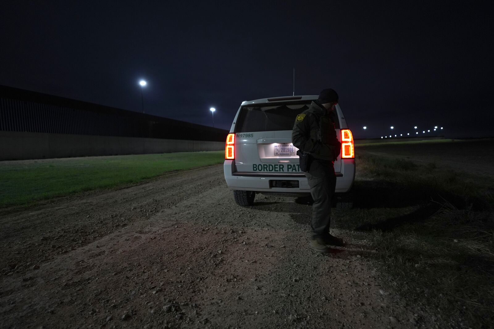 A border patrol agent walks along the border wall near the Rio Grande at the U.S.-Mexico border, Thursday, Feb. 13, 2025, in McAllen, Texas. (AP Photo/Eric Gay)