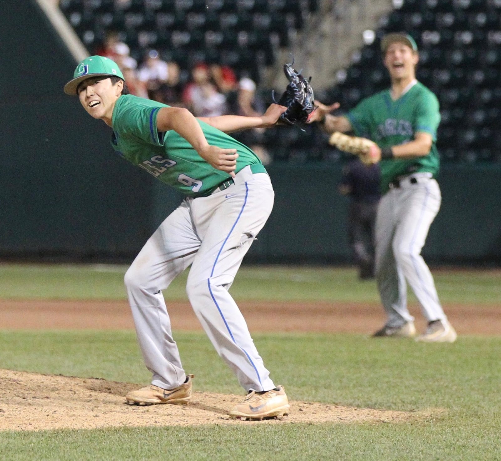 Chaminade Julienne pitcher Nick Wissman, left, and first baseman David Ernst throw their gloves in the air after a victory against Wapakoneta in the Division II state championship on Saturday, June 2, 2018, at Huntington Park in Columbus. David Jablonski/Staff