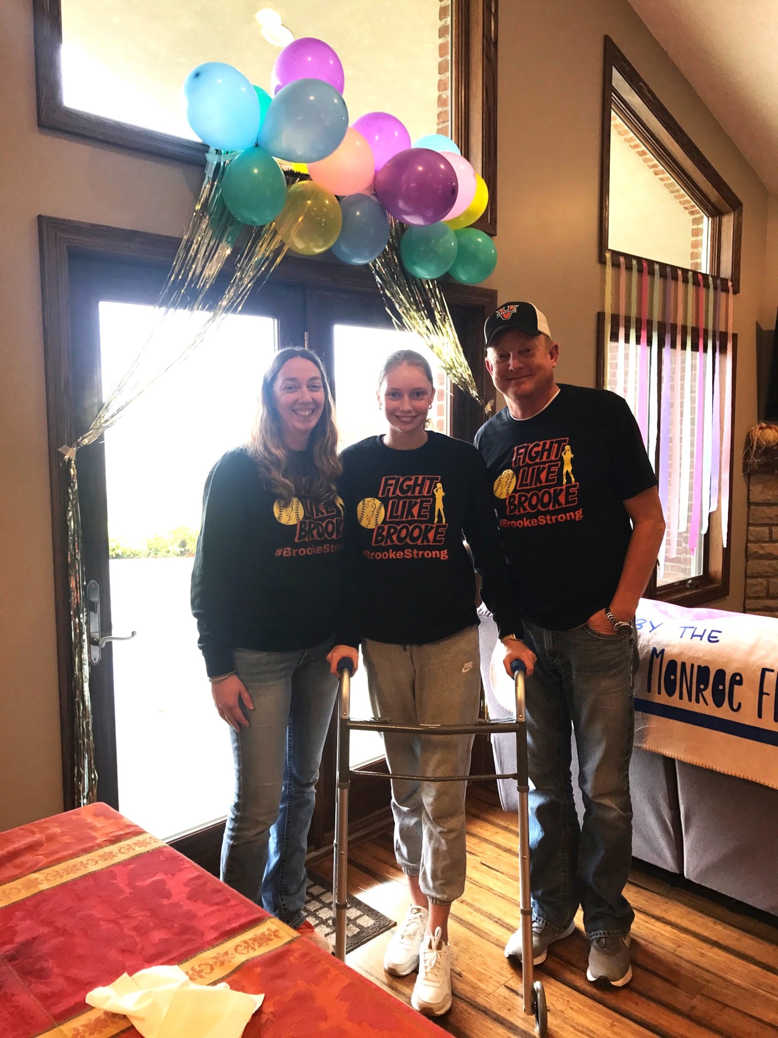 Versailles junior Brooke Bergman with her parents – Gwen and Kevin – in their home in New Weston a couple of days after being released from the hospital five days earlier. She spent 52 days in Miami Valley Hospital in Dayton and the Ohio State Dodd Rehabilitation Hospital in Columbus following her serious auto accident coming home from school on September 18. Tom Archdeacon/CONTRIBUTED