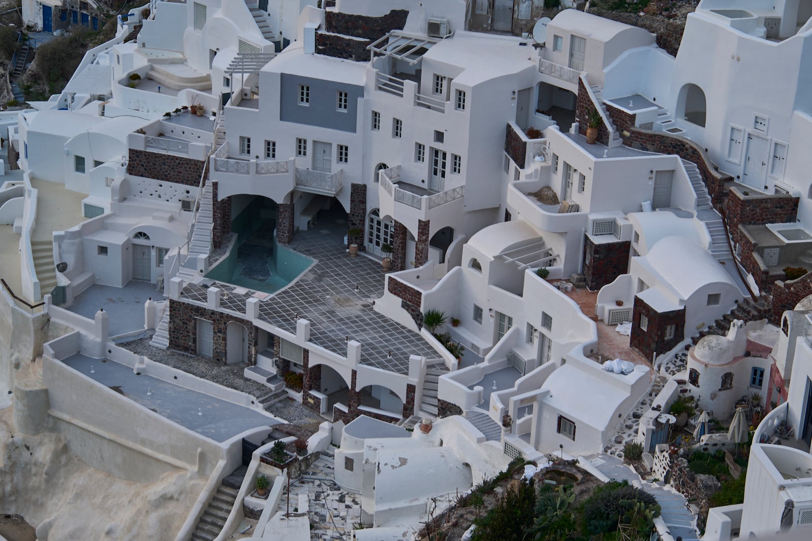 An empty swimming pool is seen in a group of clifftop buildings in the town of Oia on the earthquake-struck island of Santorini, Greece, Tuesday, Feb. 4, 2025. (AP Photo/Petros Giannakouris)