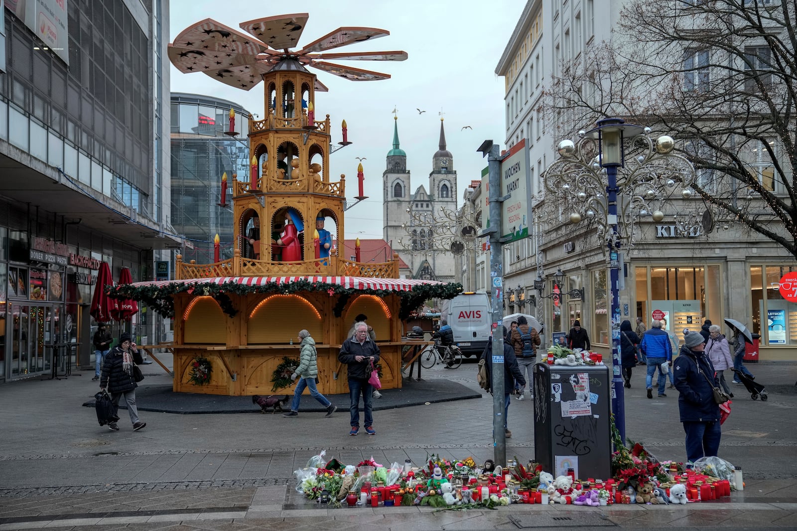 People walk at the Christmas Market, where a car drove into a crowd on Friday evening, in Magdeburg, Germany, Monday, Dec. 23, 2024. (AP Photo/Ebrahim Noroozi)