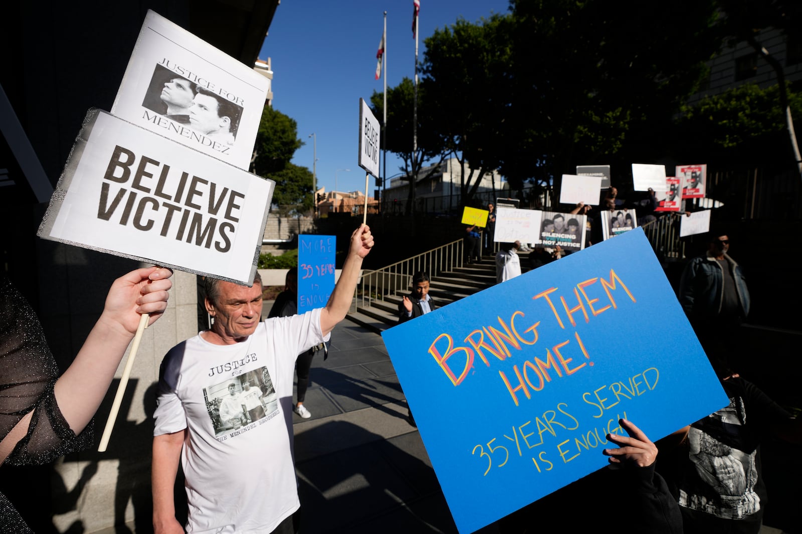 Supporters hold signs during a press conference regarding developments in the Menendez brothers case Thursday, March 20, 2025, in Los Angeles. (AP Photo/Damian Dovarganes)