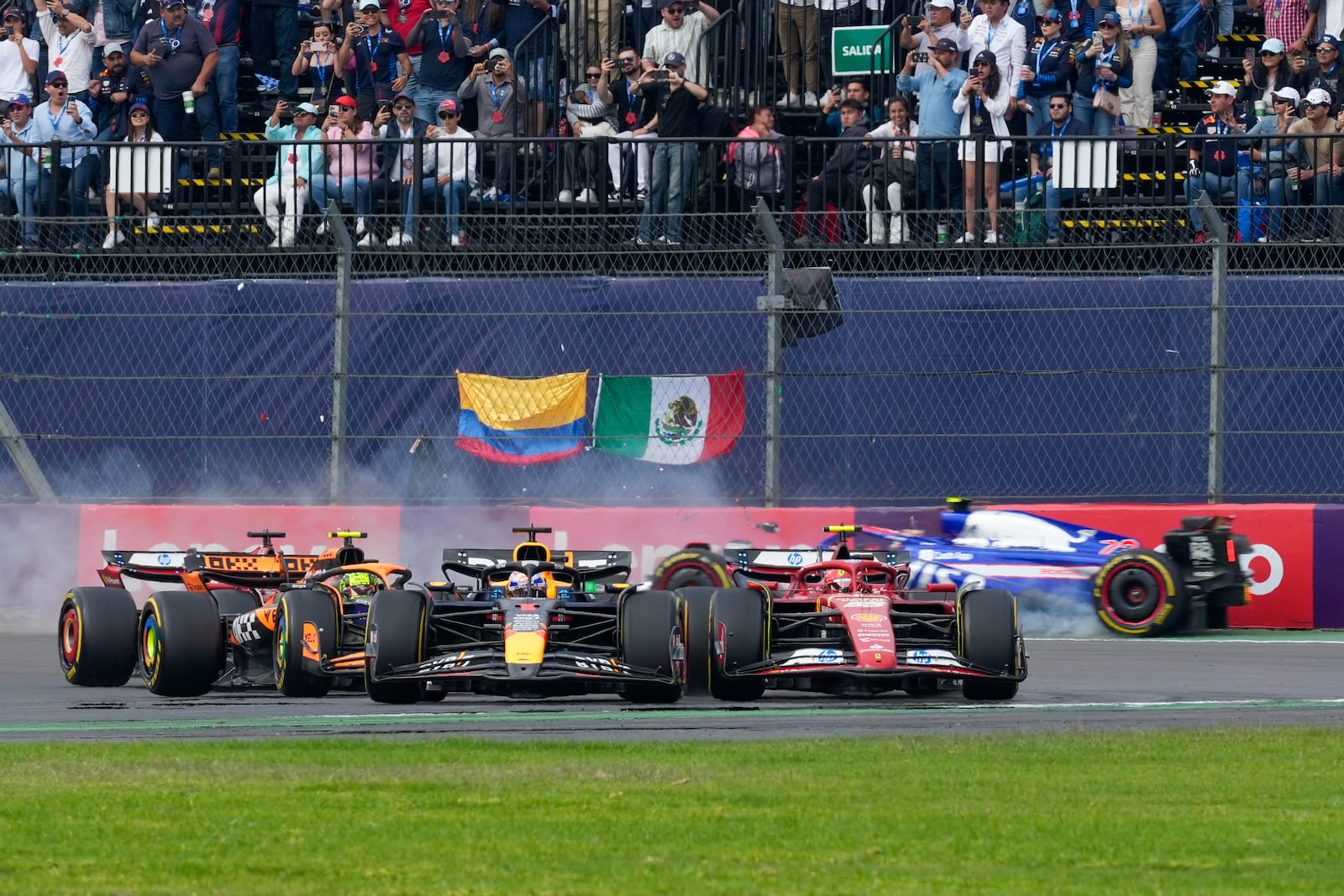 RB driver Yuki Tsunoda of Japan, back, crashes during the Formula One Mexico Grand Prix auto race at the Hermanos Rodriguez racetrack in Mexico City, Sunday, Oct. 27, 2024. (AP Photo/Moises Castillo)