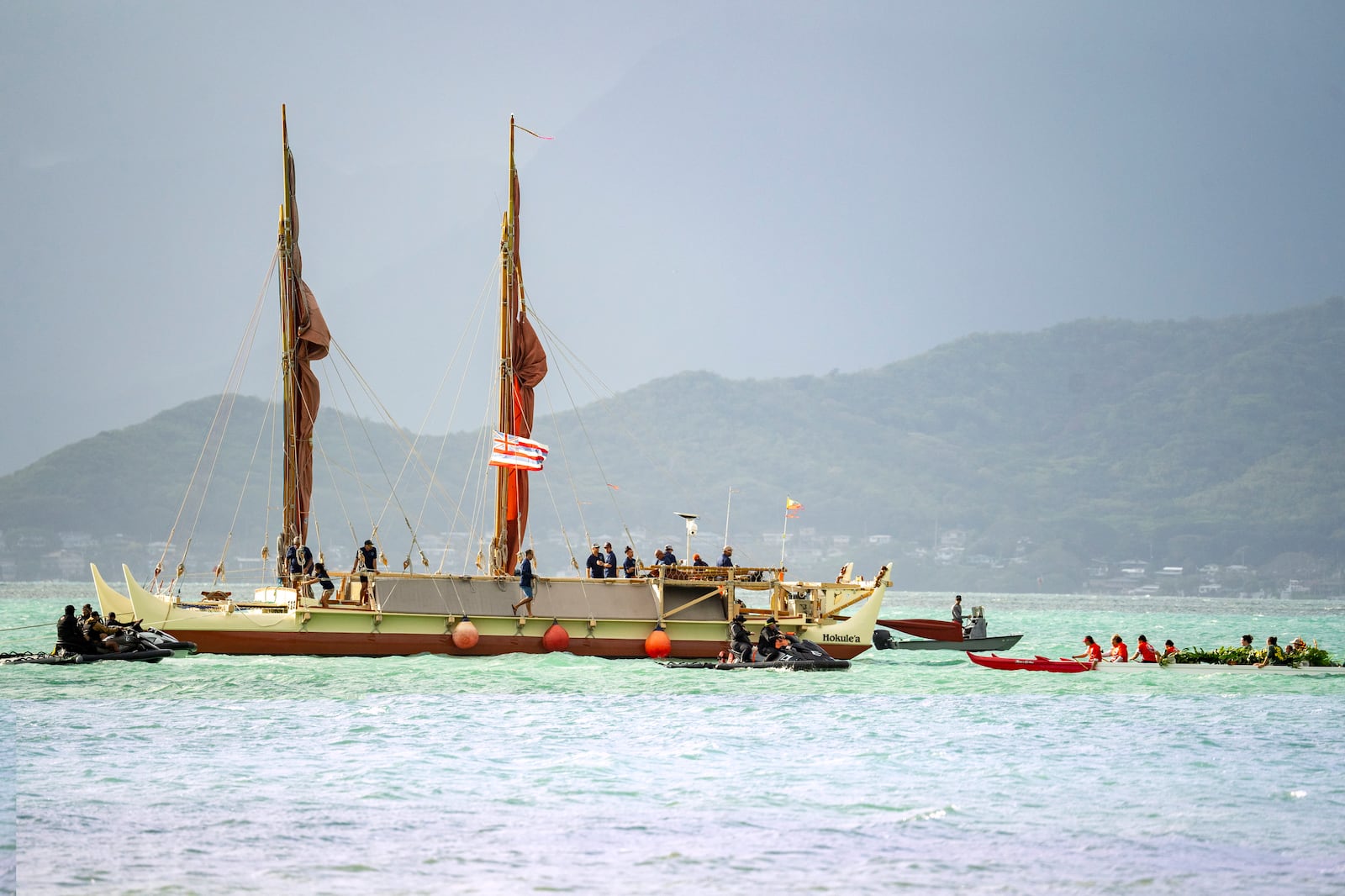 Kaneohe canoe club welcomes Hokulea as it arrives the shore of Kualoa Regional Park before Hokulea's 50th birthday commemoration, Saturday, March 8, 2025, in Kaneohe, Hawaii. (AP Photo/Mengshin Lin)