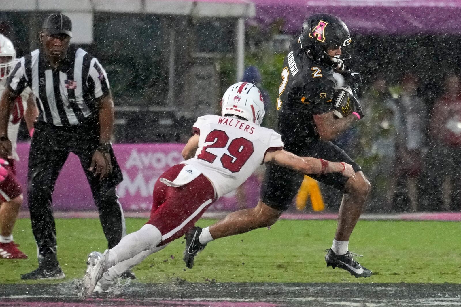 Appalachian State wide receiver Kaedin Robinson (2) runs after a reception as Miami (Ohio) defensive back Silas Walters (29) tries to stop him during the first half of the Cure Bowl NCAA college football game, Saturday, Dec. 16, 2023, in Orlando, Fla. (AP Photo/John Raoux)