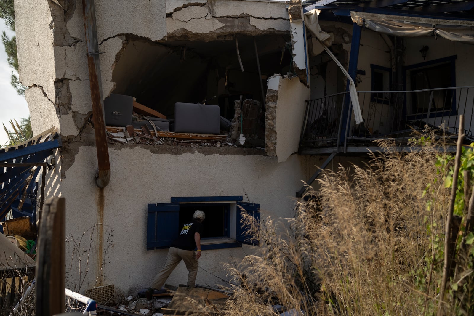 Orna Zilberstine checks a damaged house of a family friend, that was hit by a rocket fired from Lebanon, in the Kibbutz Manara, northern Israel, Thursday, Nov. 28, 2024. (AP Photo/Leo Correa)