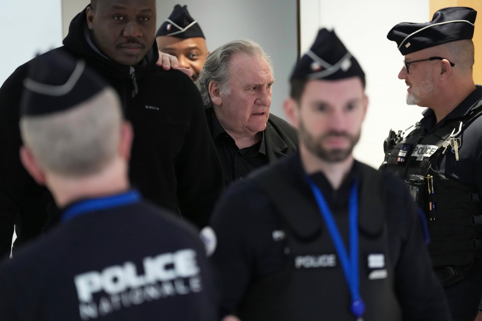 Actor Gerard Depardieu, center, returns to the courtroom after a break for his trial for the alleged sexual assaults of two women on a film set in 2021, Tuesday, March 25, 2025 in Paris. (AP Photo/Aurelien Morissard)