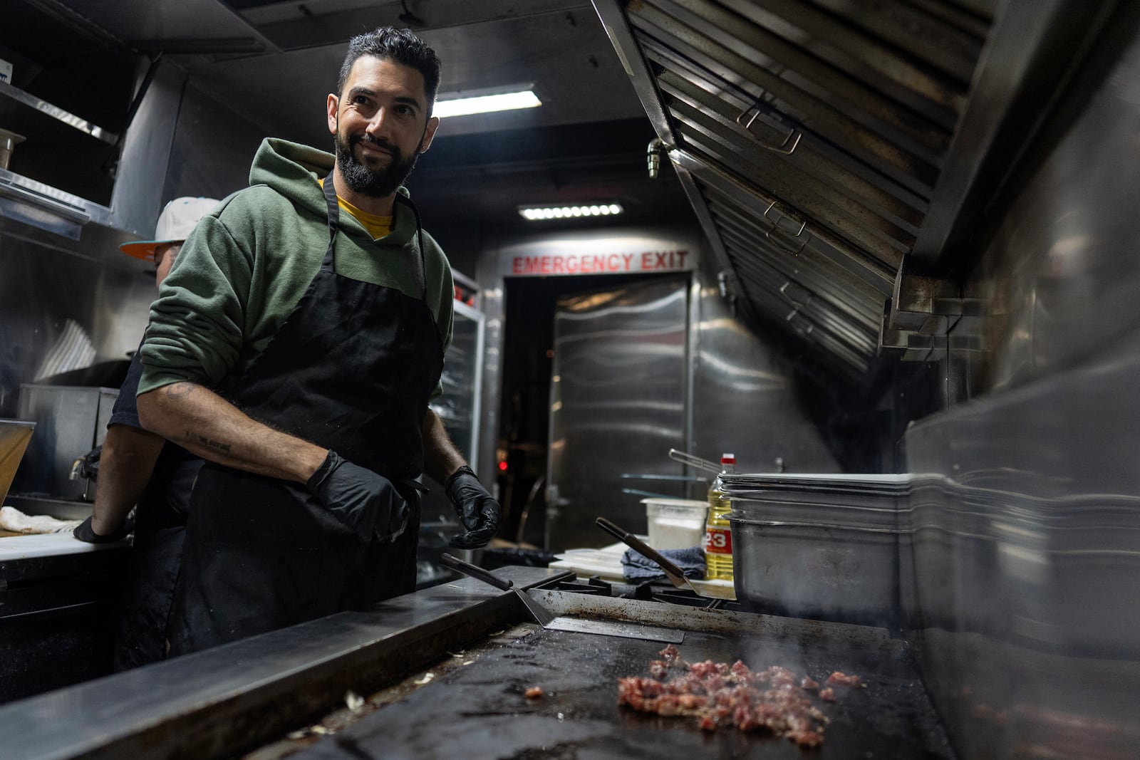 World Central Kitchen Chef Corp member Daniel Shemtob cooks meat for burritos in his food truck, The Lime Truck, for Eaton Fire first responders at the Rose Bowl Stadium, Wednesday, Jan. 15, 2025, in Pasadena, Calif. (AP Photo/Carolyn Kaster)