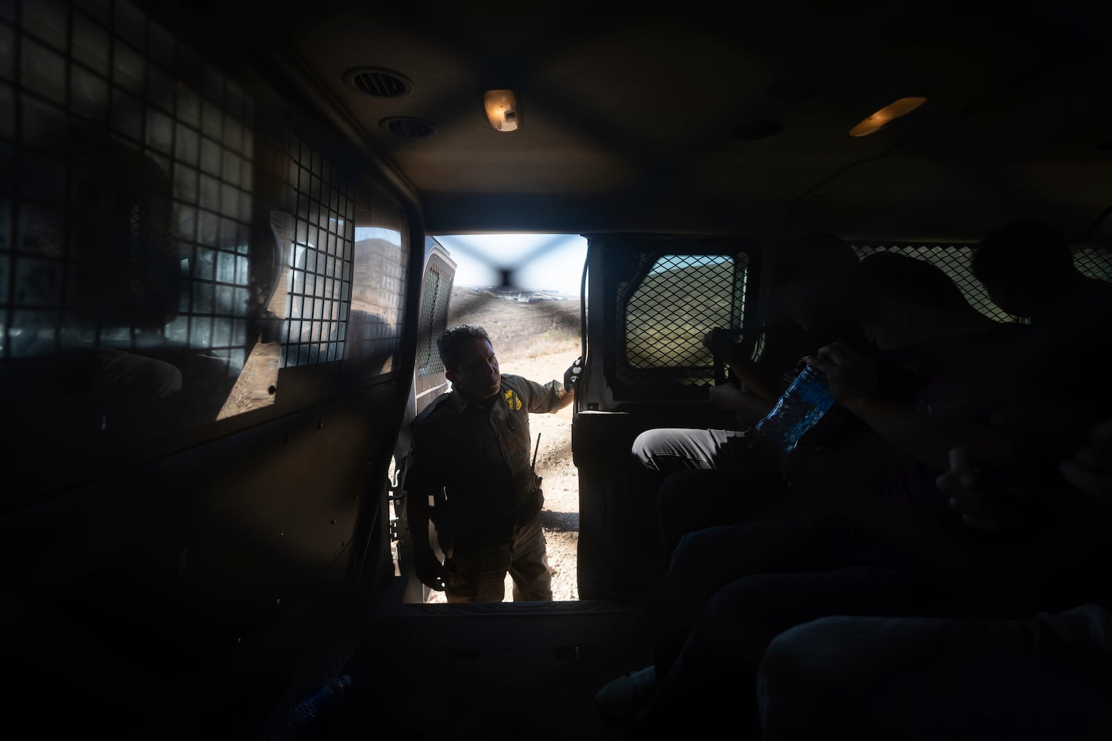 Border Patrol Agent Gutierrez instructs four men in a van after the group crossed the border illegally through a gap in two walls separating Mexico from the United States before turning themselves in, Thursday, Jan. 23, 2025, in San Diego. (AP Photo/Gregory Bull)