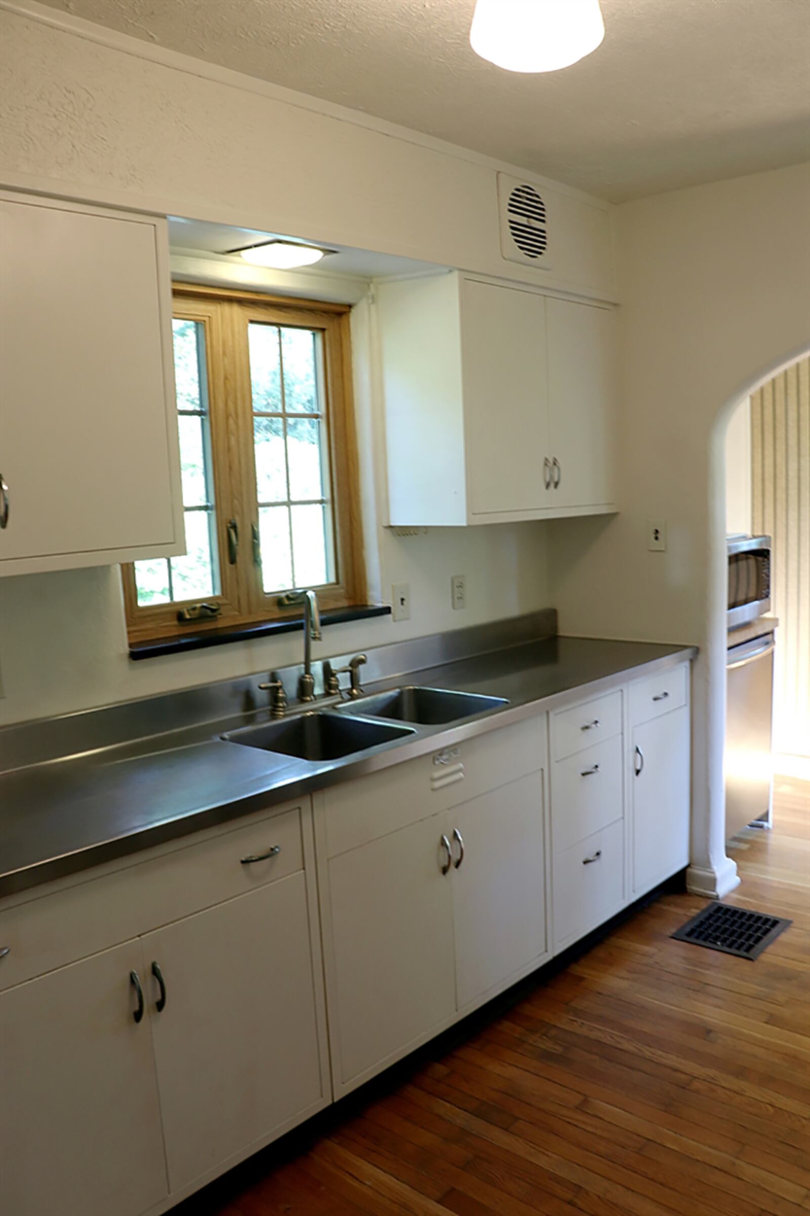 Off the dining room, the galley kitchen has been updated with painted wood cabinetry and a stainless-steel countertop with adjoining double sink. The stove nook is the final part of the renovation, allowing for the buyer’s choice of gas or electric range. CONTRIBUTED PHOTO BY KATHY TYLER